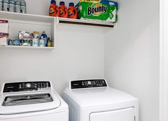 a white washer and dryer sit next to each other in a laundry room