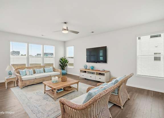 A living room with a white ceiling and a television on the wall.