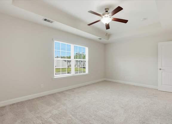 A room with a ceiling fan and a window with blinds.