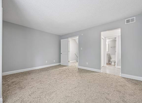 A room with a carpeted floor and a doorway leading to another room.