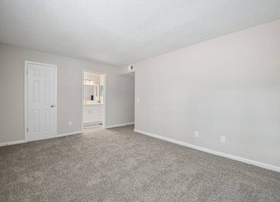 A room with a carpeted floor and white walls.