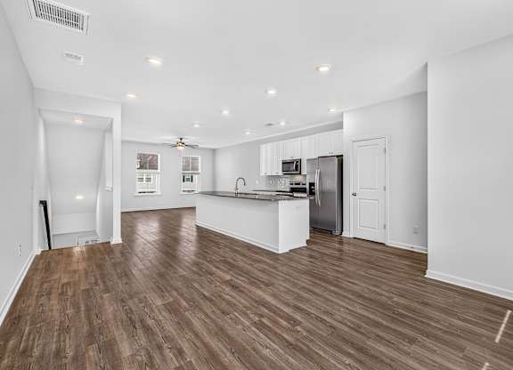 A spacious kitchen and living room with wood flooring.