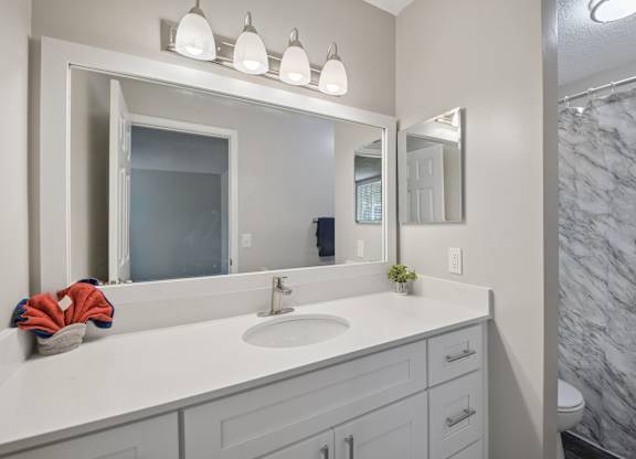 A bathroom with a marble wall and a white sink.