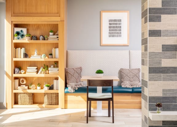 a room with a table and a couch in the background and a bookcase in the foreground