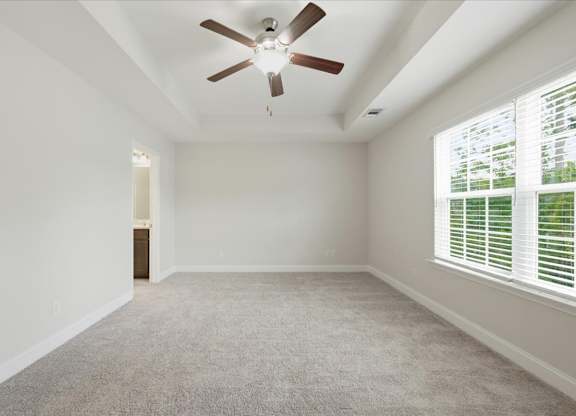 A room with a ceiling fan and carpeted floor.