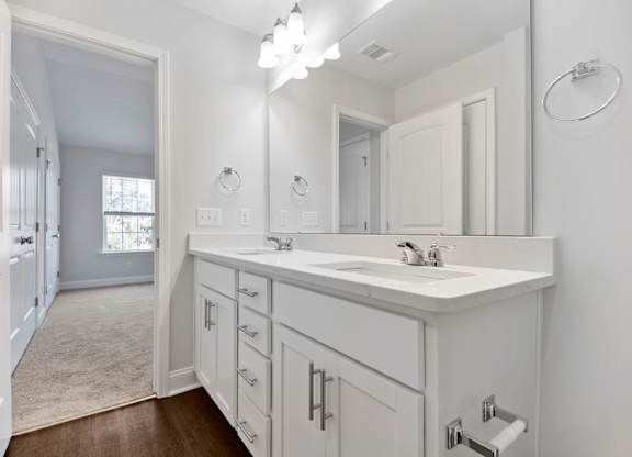 a white bathroom with a large mirror and a sink
