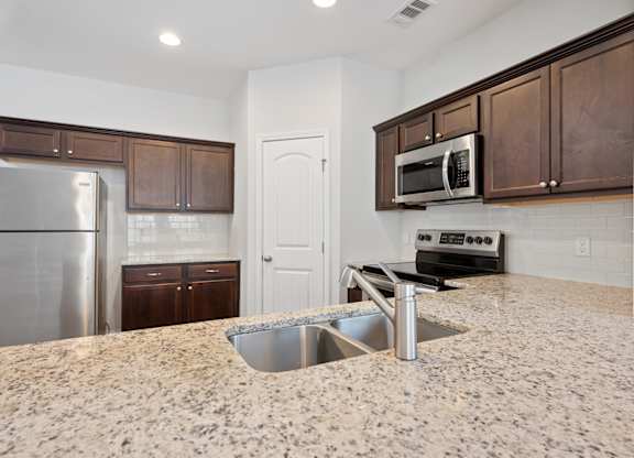 Harris Trail Luxury Townhomes for rent Richmond Hill, GA photo of a kitchen with granite counter tops and stainless steel appliances