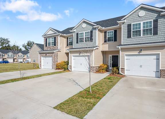 Omnia at Richmond Hill Townhomes in Georgia photo of exterior homes with white doors on a lengthy driveway