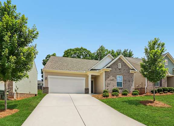 A residential house with a driveway in front.