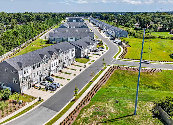 A large, modern building complex with a parking lot in front.