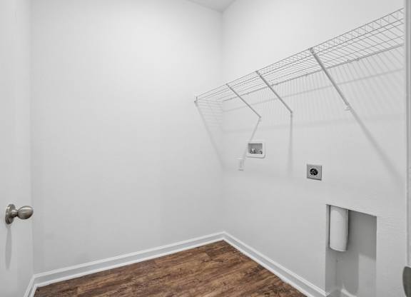 A room with a door and a shelf on the wall.