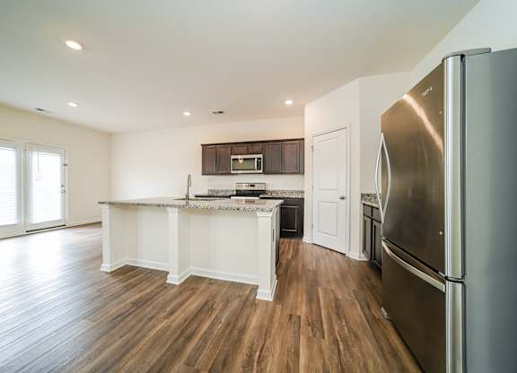 A kitchen with a refrigerator on the right side.