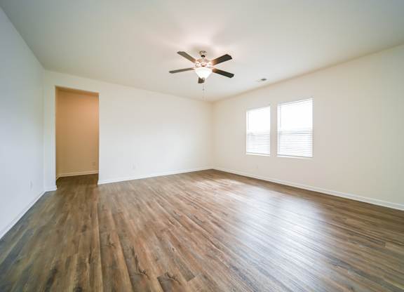 A room with wooden floors and a ceiling fan.