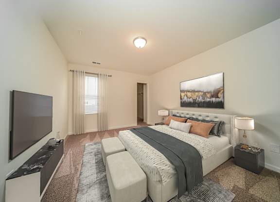 A bedroom with a large bed and a flat screen TV.