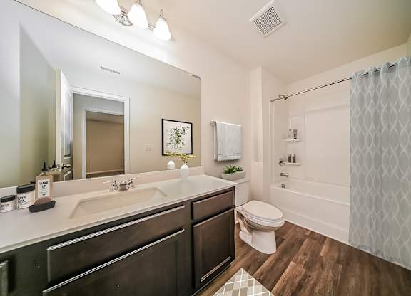 A bathroom with a white shower curtain and a white toilet.