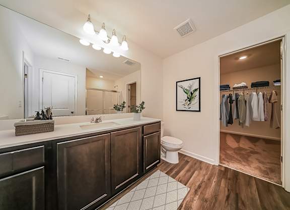 A bathroom with a toilet, sink, and a mirror.