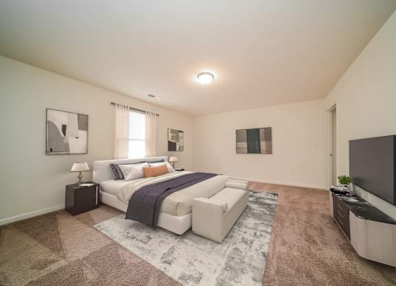 A bedroom with a large bed and a flat screen TV mounted on the wall.