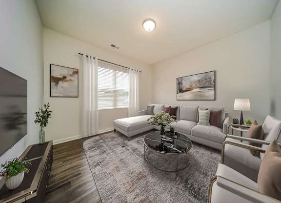 A living room with a grey sofa, a coffee table, and a painting on the wall.