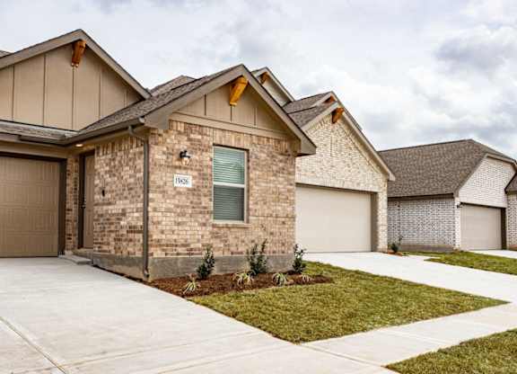 a home with a concrete driveway and two garages