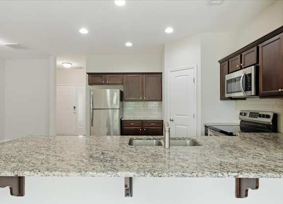 A kitchen with granite countertops and stainless steel appliances.