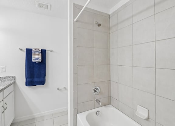 A white bathroom with a blue towel hanging on the wall.