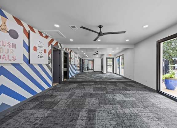A hallway with a blue and white striped wall and a sign that says "rush to our goals".