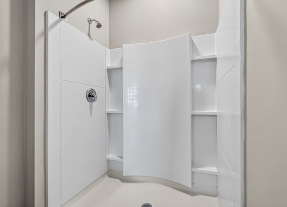 A white bathroom with a walk in shower.