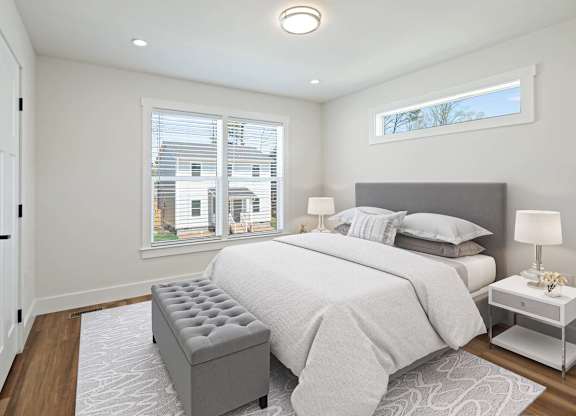 Bright bedroom at Belle Meadow with large windows, modern decor, and neutral tones.