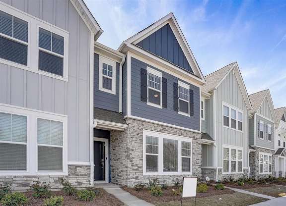 A row of houses with a mix of grey and white siding.