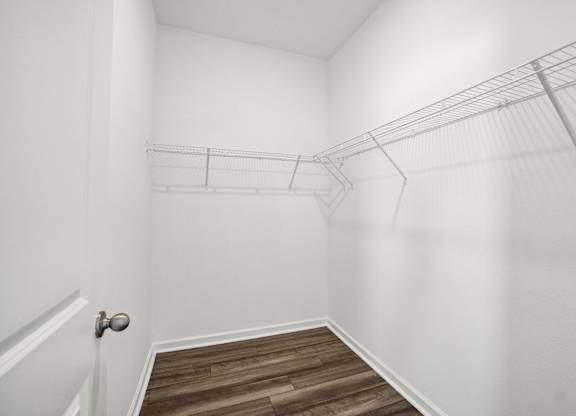 A white room with a door and a shelf.