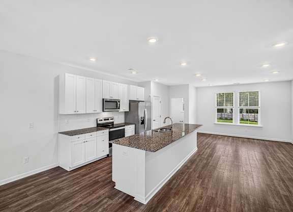 A modern kitchen with white cabinets and a central island.