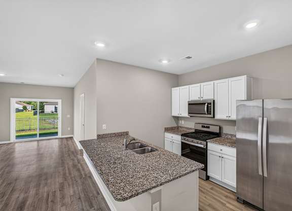 A kitchen with a granite countertop and stainless steel appliances.