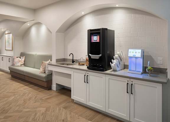 A modern kitchen with a coffee machine and a fridge.