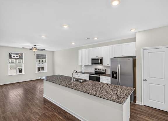 A kitchen with a granite countertop and stainless steel appliances.