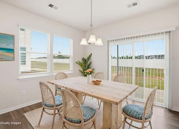 A dining room with a wooden table and chairs.