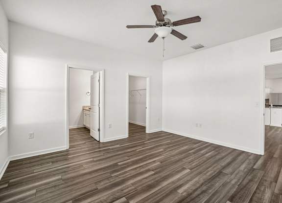 A room with a ceiling fan and wooden flooring.