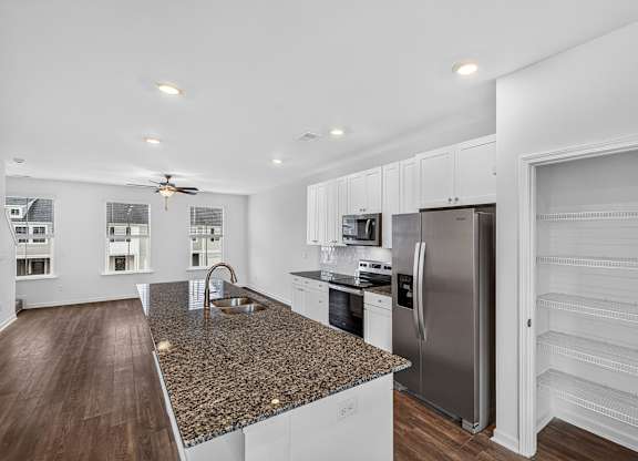 A kitchen with a granite countertop and stainless steel appliances.