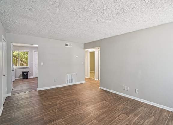 A room with wooden flooring and white walls.