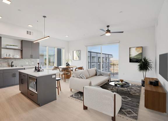 A modern kitchen with a large island and a dining area with a view of the city.
