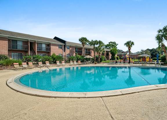 Outdoor resort-style pool area with lounge chairs at Townsend Apartments in Jacksonville near Atlantic Beach, Florida.