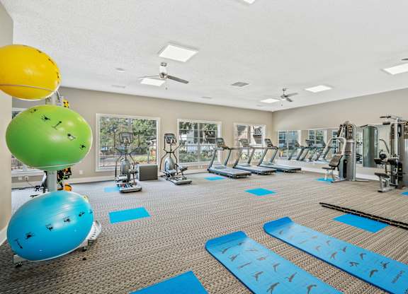 Fitness center featuring modern equipment and a yoga mat at Townsend Apartments in Jacksonville near Atlantic Beach, Florida.