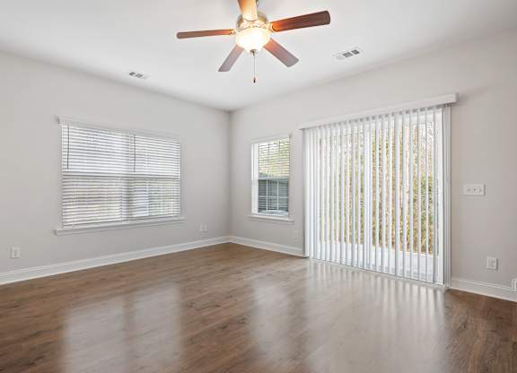 Harris Trail Luxury Townhomes for rent Richmond Hill, GA photo of an empty living room with a ceiling fan and a window
