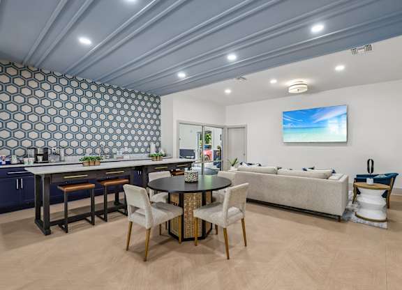 A modern kitchen with a dining table and chairs.