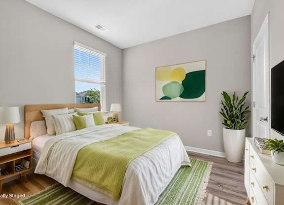 A bedroom with a bed, nightstands, and a painting on the wall.