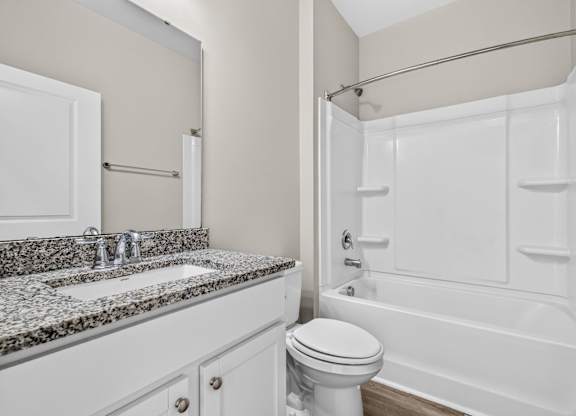 A white bathroom with a sink, toilet, and bathtub.