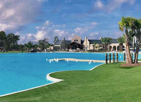 a large pool with a house in the background