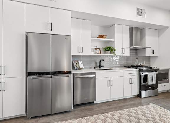 A modern kitchen with a refrigerator, oven, and microwave.