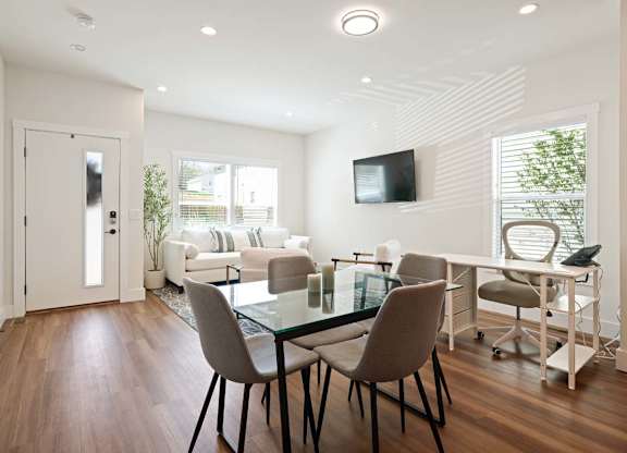 A modern living room with a glass table and chairs.