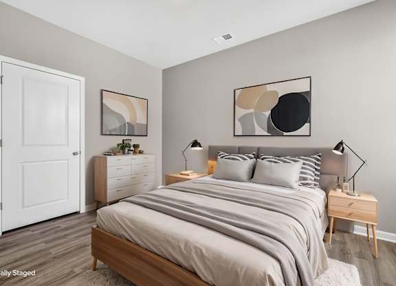 A bedroom with a large bed and a white door.
