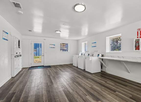 A room with white walls and wooden floors has a blue mat on the floor.